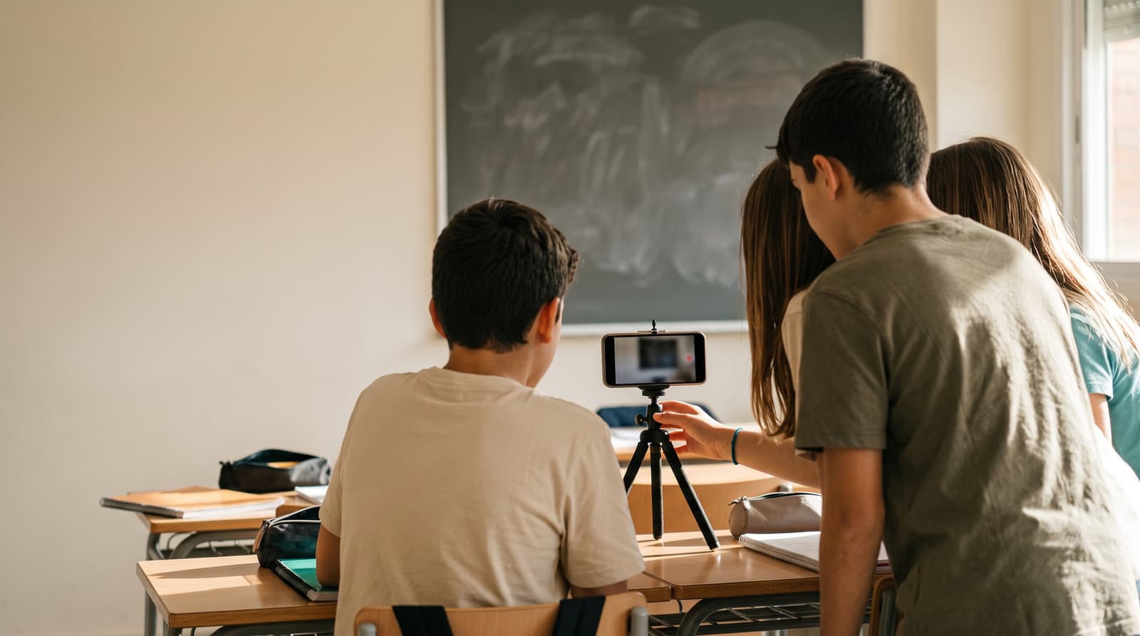 Students filmed from behind, recording with a phone on a tripod in a classroom in Bilbao